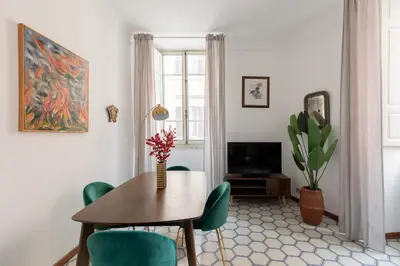 a dining room with a table and green chairs at iFlat Barberini 's Dream in Rome