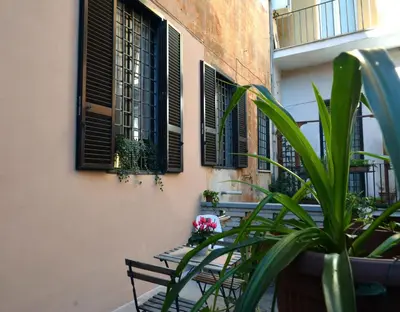 a patio with chairs and plants in front of a building at Petit loft de Rome Vatican Apartment in Rome