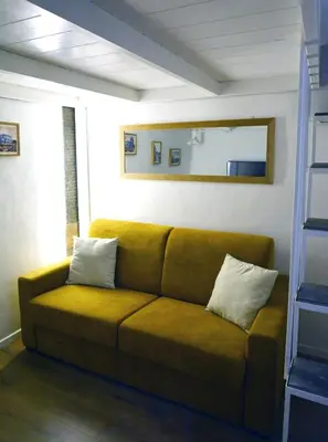 a living room with a brown couch with two pillows at Petit loft de Rome Vatican Apartment in Rome
