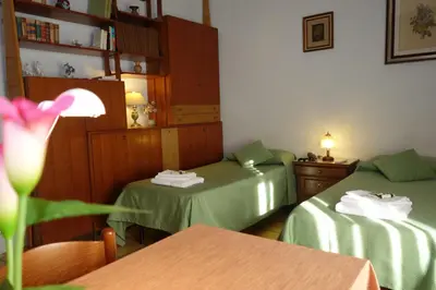 a room with two beds and a table with a flower at B&B Rome Downtown Deluxe in Rome