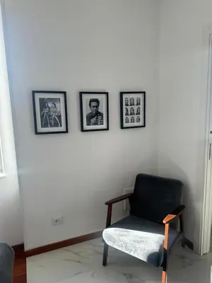 a room with a chair and three pictures on the wall at Maison Merulana Colosseo in Rome