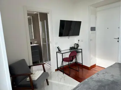 a bedroom with a desk and a television on a wall at Maison Merulana Colosseo in Rome