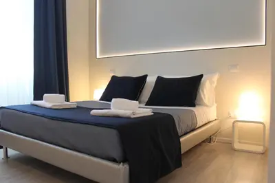 a bedroom with a large bed with black and white pillows at Little Rose Lodge in Rome