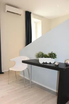 a black table and a white chair in a room at Little Rose Lodge in Rome