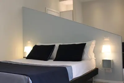a bedroom with a bed with two black pillows at Little Rose Lodge in Rome