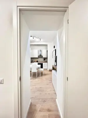 a hallway leading into a kitchen with white walls and wood floors at Saint Peter 78 - Design Apartment in Rome