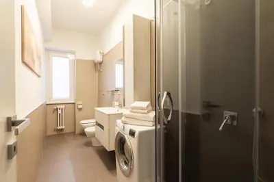 a bathroom with a toilet and a washing machine at Albadomus Apartment in Rome