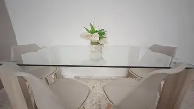 a glass table with white chairs and a vase with flowers at ROMA BeMa Apartment - charme e relax a due passi dal Vaticano in Rome