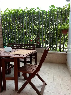 a wooden table and a chair next to a table and a fence at Marcus Modern Apartment in Rome