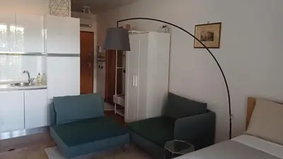 a living room with a couch and a chair and a lamp at Marcus Modern Apartment in Rome