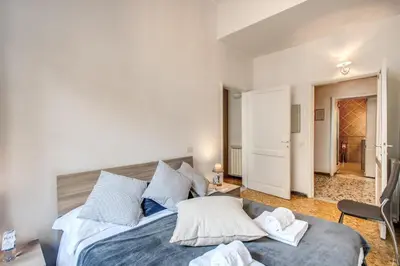 a bedroom with a large bed with white and blue pillows at Suite Experience Termini Station Apartment in Rome