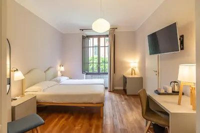 a bedroom with a bed and a desk and a tv at HOTEL DELLE CIVETTE in Rome