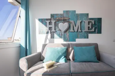 a couch with two pillows and a sign that reads home at Laterano View by Rental in Rome in Rome