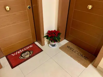 a hallway with a vase of flowers and welcome mats at 8380 Lory's House in Rome