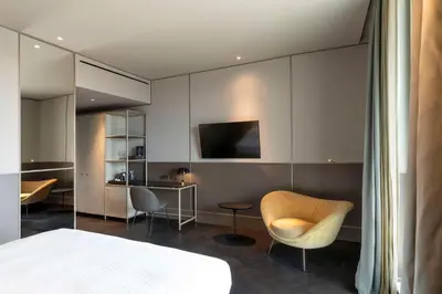 a bedroom with a bed and a chair and a desk at Radisson Collection Hotel, Roma Antica in Rome