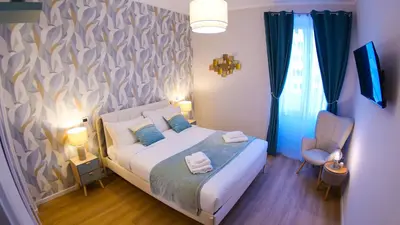 a small bedroom with a bed and a chair at Baronio Apartment in Rome