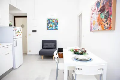 a white kitchen with a white table and a chair at Il Viandante al Pigneto - Parcheggio privato su richiesta in Rome
