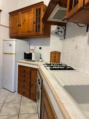 a kitchen with a stove and a white refrigerator at Ginny's Home in Rome