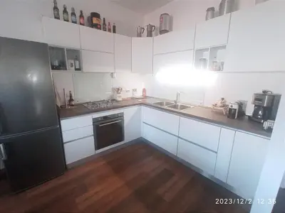 a kitchen with white cabinets and a black refrigerator at Rooftop Appia antica,silenzioso riservato two bedrooms two bathrooms in Rome