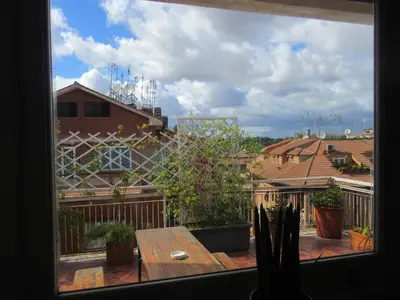 a view from a window of a patio with a wooden table at Rooftop Appia antica,silenzioso riservato two bedrooms two bathrooms in Rome