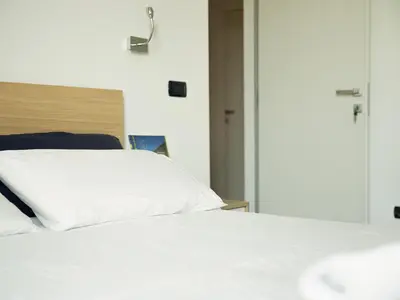 a bed with a white pillow on top of it at Room In Roma Isole in Rome
