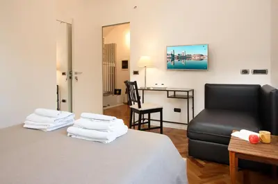 a room with a bed and a chair and a table at Room In Roma Isole in Rome