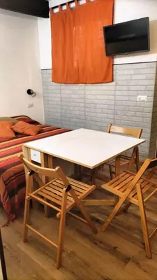 a table and chairs in a room with a bed at Trastevere Heritage Suite in Rome