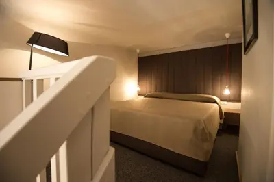 a small bedroom with a bed and a staircase at Assunta Domus in Rome