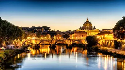 a bridge over a river with a city in the background at Kimera Luxury Apartments in Rome San Pietro in Rome