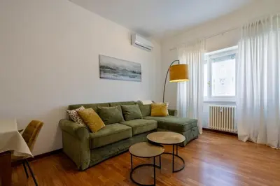 a living room with a green couch and two tables at Kimera Luxury Apartments in Rome San Pietro in Rome