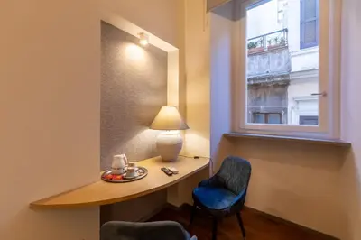 a room with a desk and a lamp and a window at Fontana di Trevi Roma Luxury Suite in Rome
