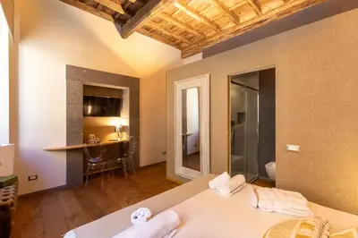 a bedroom with a bed and a table in a room at Fontana di Trevi Roma Luxury Suite in Rome