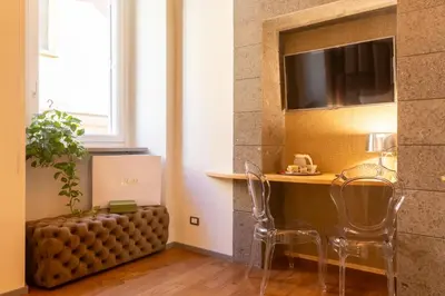 a room with a table and chairs and a television at Fontana di Trevi Roma Luxury Suite in Rome