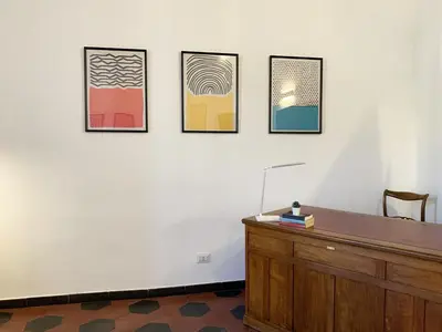 a room with a desk and four pictures on a wall at RomeAsYouLike - Vatican Apartment N°73 in Rome