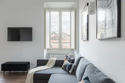 a person laying on a couch in a living room at iFlat Magnificent Central Apartment in Rome