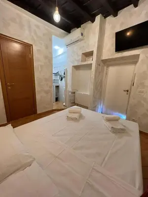 a large white bed with two towels on top of it at Magenta Collection Panico 32 in Rome