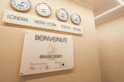 a room with clocks on the wall and a sign at Binario Zero in Rome