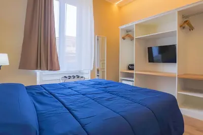 a bedroom with a blue bed and a television at Binario Zero in Rome