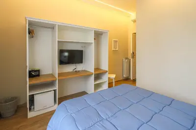 a bedroom with a blue bed and a tv at Binario Zero in Rome