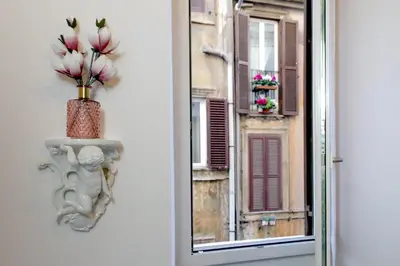 a vase with flowers in it on the side of a window at Luxury apartment in Rione Monti in Rome
