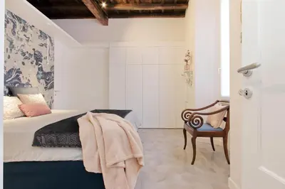 a bedroom with a bed and a chair at Luxury apartment in Rione Monti in Rome