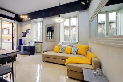 a living room with a couch and yellow pillows at Charming loft with terrace at the Quirinale in Rome