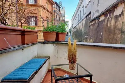 a balcony with a blue bench and a glass table at Charming loft with terrace at the Quirinale in Rome