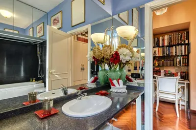 a bathroom with a sink and a vase of flowers at Vespasiano Luxury apartment for 4 in Rome