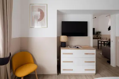 a living room with a tv and a yellow chair at Japandi Space by Nosdom Properties in Rome