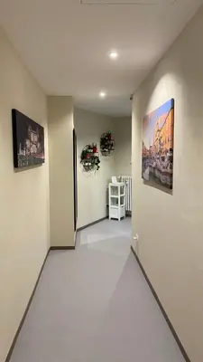 a hallway with a white floor and paintings on the walls at Ele rooms San Pietro in Rome