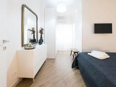 a white bedroom with a bed and a mirror at Casa TPZ Metro Baldo - Close To Vatican in Rome