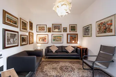 a living room with a couch and pictures on the wall at Lungotevere Testaccio Rooftop in Rome