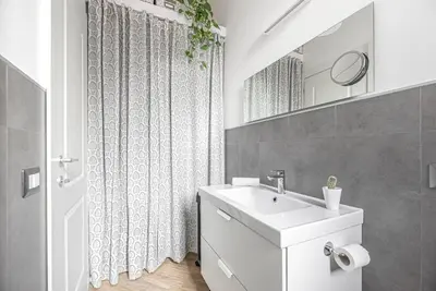 a white bathroom with a sink and a mirror at Lungotevere Testaccio Rooftop in Rome