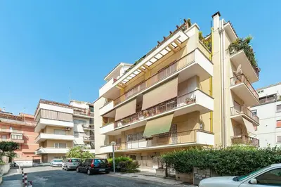 a tall building with cars parked in a parking lot at St. Peter - Loft at 50m from Metro (up to 4) in Rome